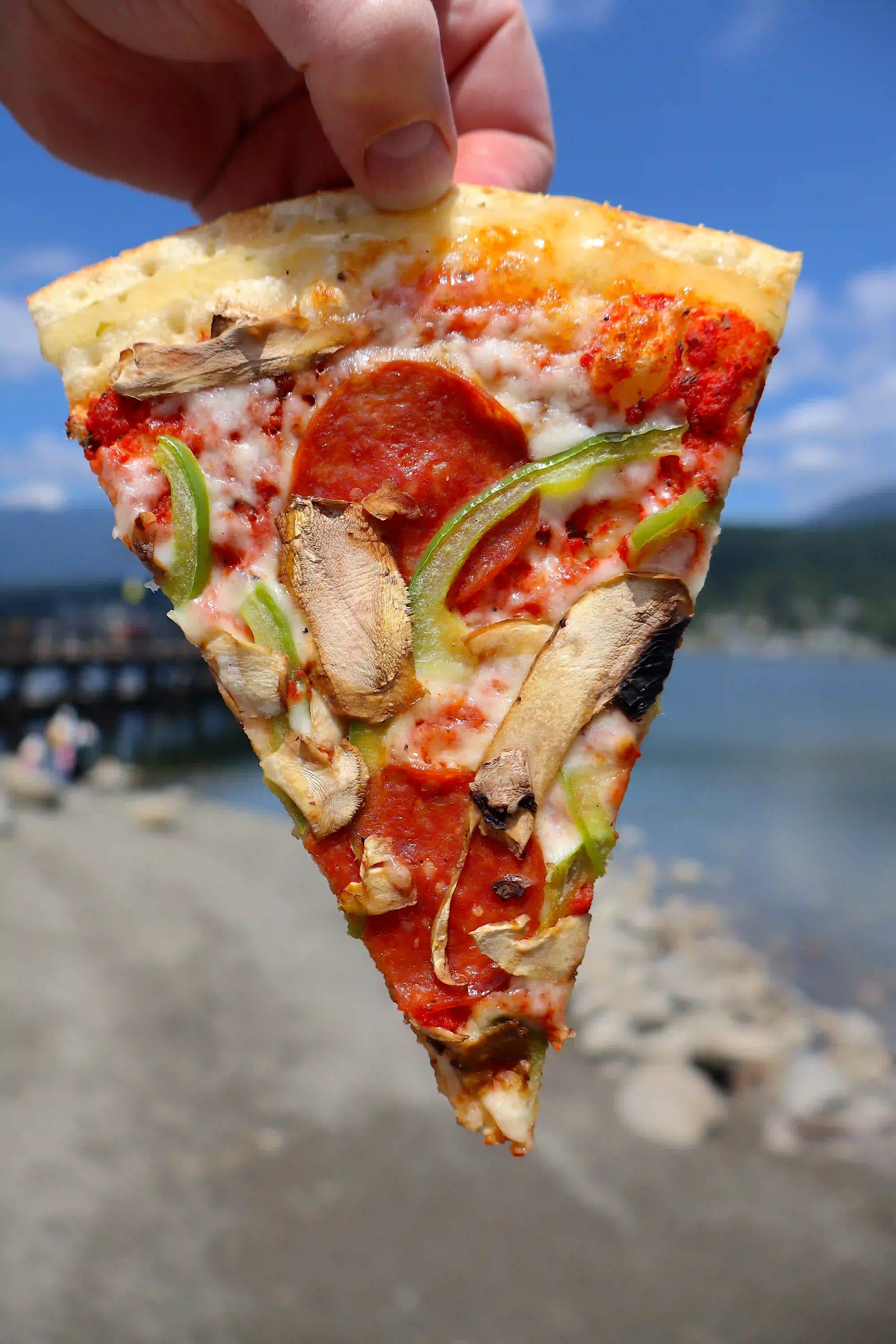 A dilicious cup and char pepperoni pie with a bridge in the distance.